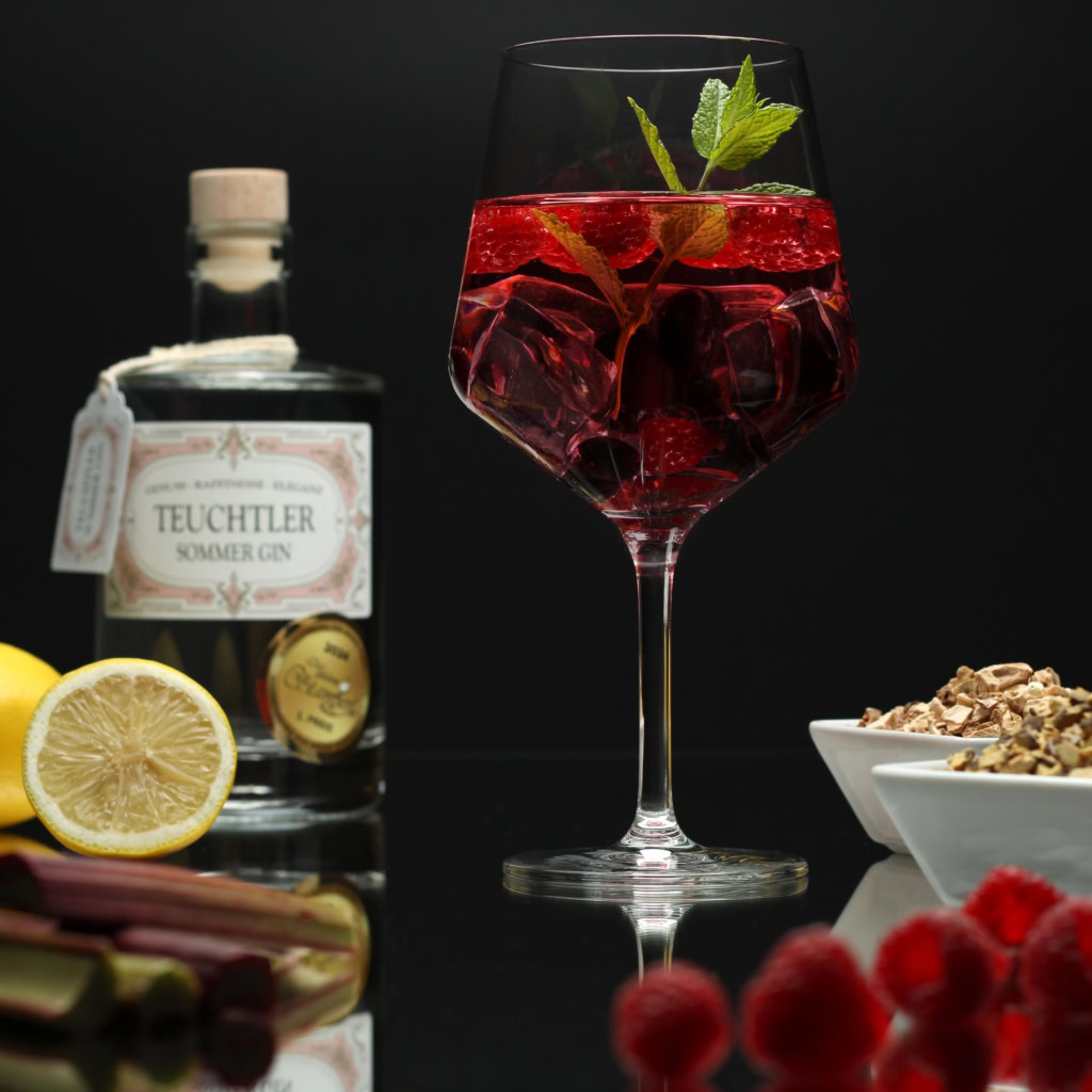Sommer Gin Cocktail mit Teuchtler Sommer Gin, Himbeer-Rhabarber Tonic, Himbeeren, Minze und Eis im Weinglas